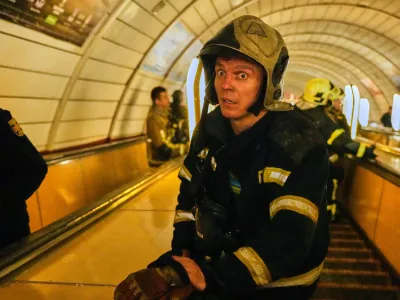 A firefighter reacts on missiles' strikes as he goes down the escalator to a metro shelter during Russia's missile and drone attacks on capital Kyiv, Ukraine, early Sunday, May 24, 2026. (AP Photo/Efrem Lukatsky)