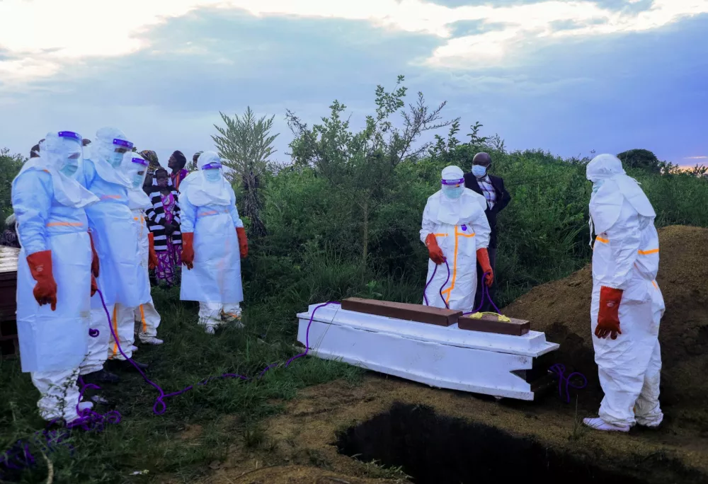 Congolese medical workers wearing personal protective equipment (PPE) prepare to bury the coffin of a patient who died of Ebola, as authorities intensify efforts to contain a new Ebola outbreak involving the Bundibugyo strain outbreak in Rwampara outside Bunia, Ituri province, Democratic Republic of Congo, May 21, 2026. REUTERS/Stringer