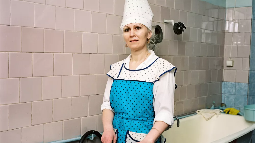 Angarsk, 2008Een werkneemster maakt een vis klaar in de kantine van de cementfabriek. De fabriek heeft twee keer de Leninorde gekregen. Toen heeft de perestrojka alles kapot gemaakt. 'We zijn achttien jaar kwijtgeraakt. Het collectief is uit elkaar gevallen.' / A worker preparing a fish in the canteen of the cement factory. The factory was twice awarded the Lenin Order. Then perestroika destroyed everything. 'We lost eighteen years. The community fell apart.' GRATIS GEBRUIK VAN MAXIMAAL DRIE FOTO'S UIT DEZE PERSMAP bij artikelen of recensies in het kader van het boek of tentoonstelling 'Ordinary People' van fotograaf Rob Hornstra in het Fotomuseum Den Haag van 9 december 2023 tot 17 maart 2024.FREE USE OF MAXIMUM THREE PHOTOS FROM THIS PRESS FOLDER with articles or reviews about photographer Rob Hornstra's book or exhibition 'Ordinary People' at the Fotomuseum Den Haag from 9 December 2023 to 17 March 2024.