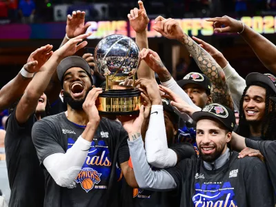 May 25, 2026; Cleveland, Ohio, USA; New York Knicks center Karl-Anthony Towns (32) and guard Jose Alvarado (5) help the team lift the trophy after defeating the Cleveland Cavaliers in game four of the eastern conference finals for the 2026 NBA playoffs at Rocket Arena. Mandatory Credit: Ken Blaze-Imagn Images