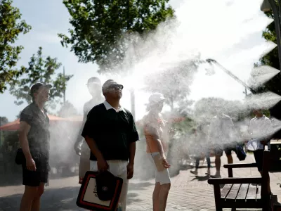 Tennis - French Open - Roland Garros, Paris, France - May 25, 2026 Spectators cool down by a water spray station during heatwave in Paris REUTERS/Benoit Tessier   TPX IMAGES OF THE DAY