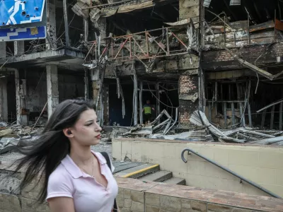 A woman walks along a ruined market, which was hit during yesterday's Russian missile and drone attack, amid Russia's attack on Ukraine, in Kyiv, Ukraine, May 25, 2026. REUTERS/Alina Smutko