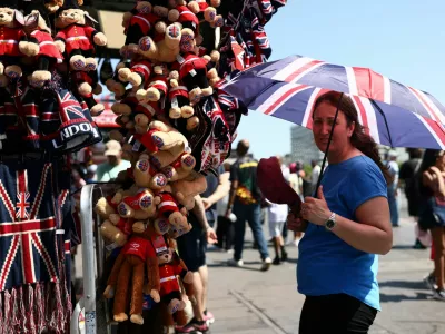 A gift stall worker shields herself from the sun with a Union Jack umbrella during a heatwave, after the UK recorded its hottest May bank holiday ever, in London, Britain, May 26, 2026. REUTERS/Jack Taylor / Foto: Jack Taylor