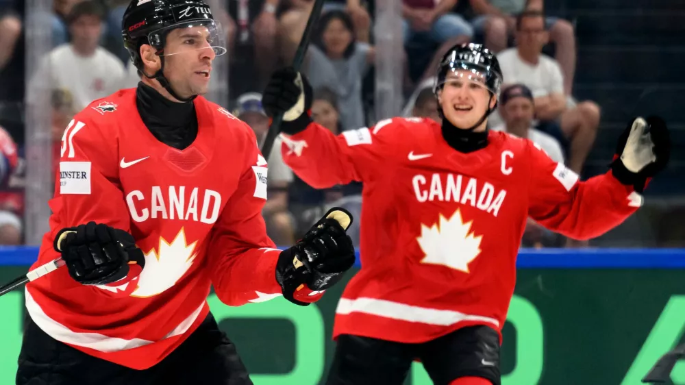 Canada's John Tavares, left, celebrates scoring with Macklin Celebrini, right, during the Group B preliminary round between the Czech Republic and Canada at the men's ice hockey world championship in Fribourg, Switzerland, Tuesday, May 26, 2026. (Laurent Gillieron/Keystone via AP)