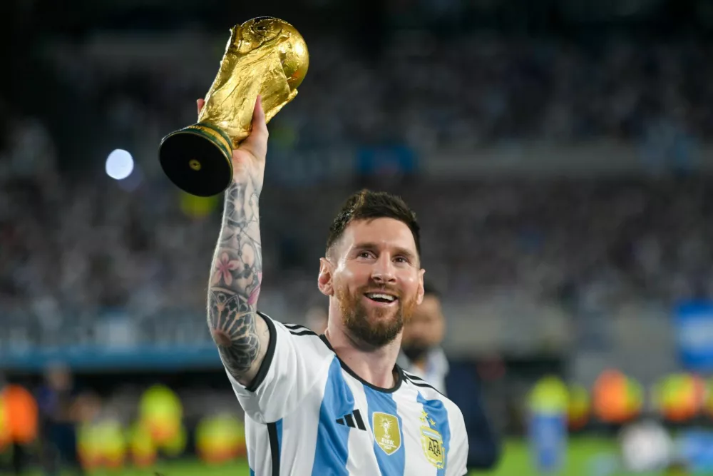 FILE - Argentina's Lionel Messi hoists the winning team replica of the FIFA World Cup trophy during a celebration ceremony for local fans after an international friendly soccer match against Panama at the Monumental stadium in Buenos Aires, Argentina, March 23, 2023. (AP Photo/Gustavo Garello, file) / Foto: Gustavo Garello
