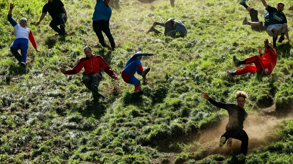 Participants compete in a race during the annual Cooper's Hill Cheese Rolling competition near Brockworth, Britain May 25, 2026. REUTERS/Isabel Infantes  TPX IMAGES OF THE DAY / Foto: Isabel Infantes