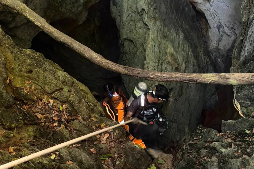 In this image released by Metta Tham Rescue Kalasin, rescuers try to reach people who have been trapped in a cave in Xaisomboun province, Laos, Tuesday, May 26, 2026. (Metta Tham Rescue Kalasin via AP)