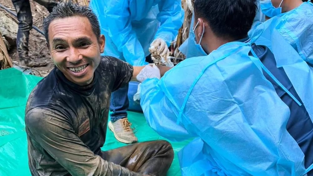 In this image released by Metta Tham Rescue Kalasin, rescuers, left, sit after rescuing people who have been trapped in a cave in Xaisomboun province, Laos. Wednesday, May 27, 2026. (Metta Tham Rescue Kalasin via AP)