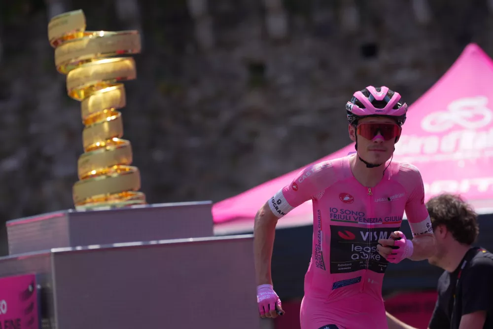 Denmark's Jonas Vingegaard walks past the trophy as he wears the pink jersey of the race overall leader ahead of the 16th stage of the Giro d'Italia cycling race from Bellinzona to Cari', Switzerland, Tuesday May 26, 2026 (Spada/LaPresse via AP)
