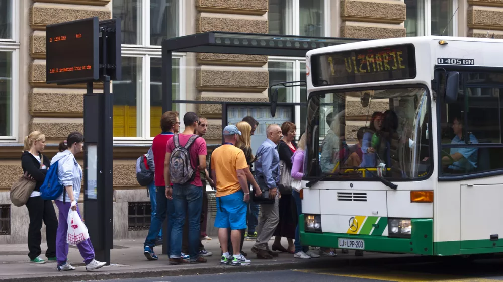 Ljubljana, Slovenia - july 26, 2011: A view of the people in line and slowly going on the bus at bus station in front of main Post office in center of Ljubljana. On left side is panelwith bus line nimber and time when it will leave.