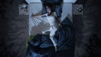 Nervous woman suffering from insomnia and lying in bed late at night, she is awake and restless, top view