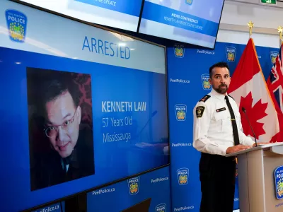 FILE - York Regional Police Inspector Simon James speaks during a news conference in Mississauga, Ont., Aug. 29, 2023, with the image of Kenneth Law, a Canadian man accused of selling lethal substances on the internet to people at risk of self harm, displayed on screen. (Arlyn McAdorey/The Canadian Press via AP, File) / Foto: Arlyn Mcadorey