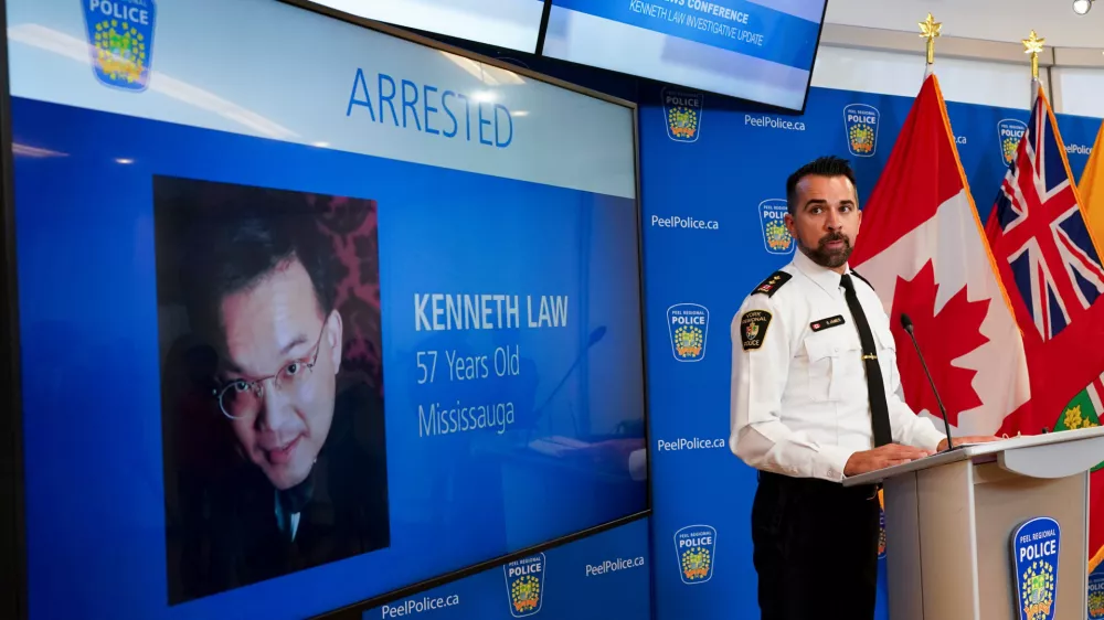 FILE - York Regional Police Inspector Simon James speaks during a news conference in Mississauga, Ont., Aug. 29, 2023, with the image of Kenneth Law, a Canadian man accused of selling lethal substances on the internet to people at risk of self harm, displayed on screen. (Arlyn McAdorey/The Canadian Press via AP, File) / Foto: Arlyn Mcadorey