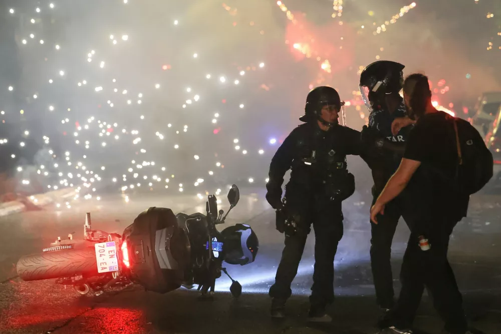 Police try to disperses PSG supporters who left off fireworks as they celebrate in Paris, Saturday, May 30, 2026 after the Champions League final soccer match between Paris Saint-Germain and Arsenal that was played in Budapest, PSG won the game. (AP Photo/Thomas Padilla)