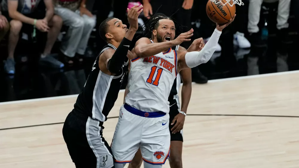 New York Knicks guard Jalen Brunson (11) drives past San Antonio Spurs forward Victor Wembanyama, left, during the first half of Game 1 of the NBA Finals basketball series, Wednesday, June 3, 2026, in San Antonio. (AP Photo/David J. Phillip)