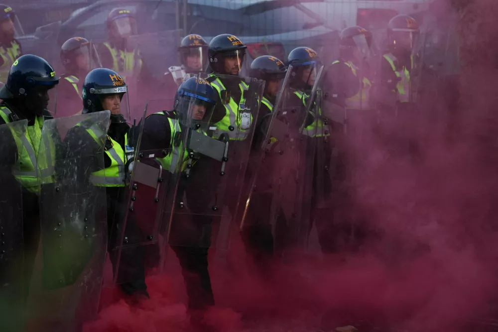 Police officers stand guard amid colored smoke during a demonstration following the conviction of Vikrum Digwa for the murder of student Henry Nowak, in Southampton, Britain, June 2, 2026. REUTERS/Isabel Infantes