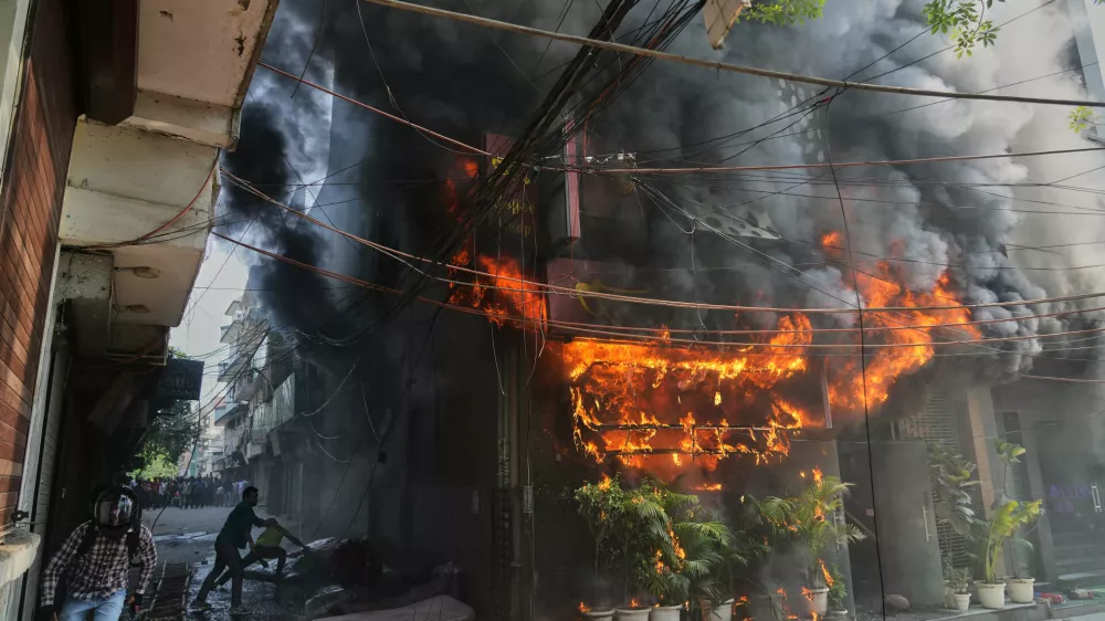 Local people attempt to douse a fire at a hotel in New Delhi, India, Wednesday, June 3, 2026. (AP Photo/Manish Swarup)