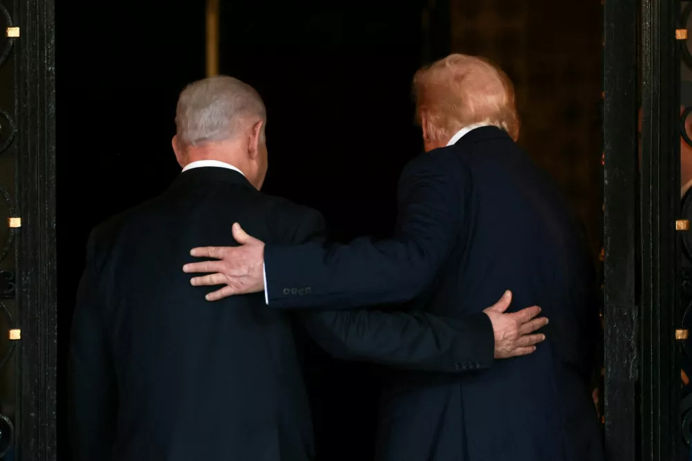 FILE PHOTO: U.S. President Donald Trump and Israeli Prime Minister Benjamin Netanyahu embrace as they walk into Trump's Mar-a-Lago club in Palm Beach, Florida, U.S., December 29, 2025. REUTERS/Jonathan Ernst/File Photo