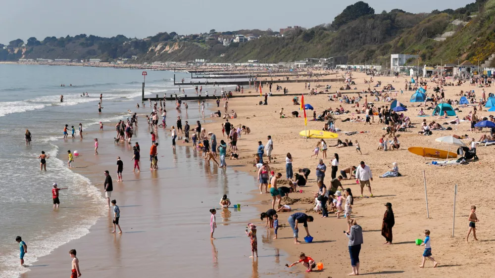 People enjoy the warm weather on Bournemouth beach, in Dorset, England, Wednesday April 8, 2026. (Andrew Matthews/PA via AP)