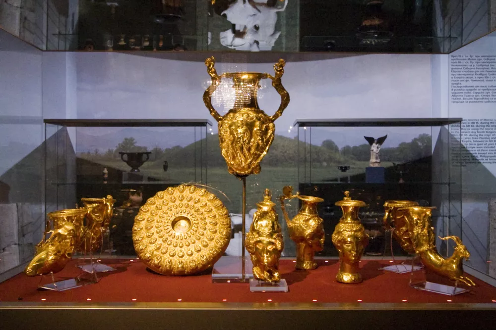 The Panagyurishte Treasure (?????????? ?????? ?????????) is a Thracian treasure discovered in 1949 two kilometres south of the town of Panagyurishte, Bulgaria. It consists of nine gold vessels (a phiale, an amphora and seven rhytons) with total weight of 6.164 kg of 23-karat gold. All of the objects are richly and skilfully decorated with scenes of Thracian myths, customs and life. The treasure is dated to the 4th-3rd centuries BC, and is thought to have been used as a royal ceremonial set, possibly by a Thracian kings. The big amphora has handles shaped as centaurs, and the openings for pouring wine represent Negro heads. Inbetween those two opinings, the amphora is decorated with a scene of Hercules fighting a snake. Three of the seven rhytons are jugs with Amazon heads and carry scenes and heroes from Greek mythology, and the phiale carries inscriptions giving its weight in Greek drachmae and Persian darics. As one of the best known surviving artifacts of Thracian culture, the treasure has been displayed at various museums around the world. When not on a tour, the treasure is the centerpiece of the Thracian art collection of the National Museum of History in Sofia. / Foto: Ann Wuyts