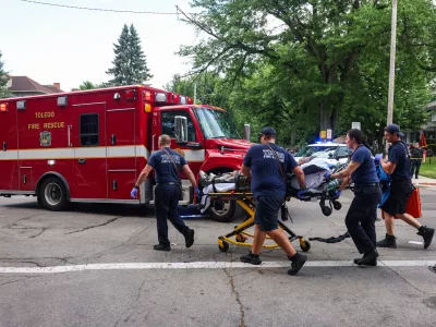 First responders help a woman who was injured at the mass shooting that left people injured at the Old West End Festival at the Agnes Reynolds Jackson Arboretum in Toledo, Ohio on Saturday, June 6, 2026. (Rebecca Benson/The Blade via AP)