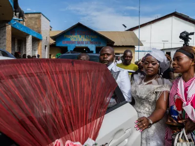 A newly married couple and guests wait outside the civil registry office amid an Ebola outbreak in Ituri Province in Bunia, Congo, Saturday, June 6, 2026. (AP Photo/Moses Sawasawa)