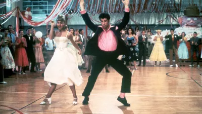1978: Australian singer and actor Olivia Newton-John and American actor John Travolta dance in a crowded high school gym in a still from the film, 'Grease,' directed by Randal Kleiser. (Photo by Paramount Pictures/Fotos International/Getty Images)