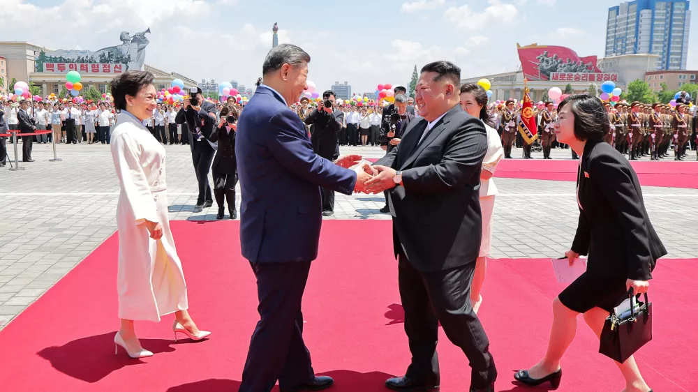 In this photo provided by the North Korean government, Chinese President Xi Jinping, center left, shakes hands with North Korean leader Kim Jong Un, center right, during a welcome ceremony in Pyongyang, Monday, June 8, 2026. Independent journalists were not given access to cover the event depicted in this image distributed by the North Korean government. The content of this image is as provided and cannot be independently verified. Korean language watermark on image as provided by source reads: "KCNA" which is the abbreviation for Korean Central News Agency. (Korean Central News Agency/Korea News Service via AP)