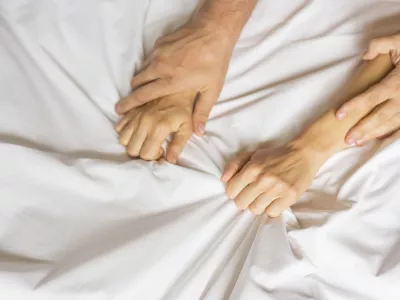 couple hands pulling white sheets in ecstasy, orgasm. Concept of passion. Orgasm. Erotic moments. Intimate concept. Sex couple. Bedroom. Hotel room. Spa / Foto: Dmitry Belyaev Getty Images/istockphoto