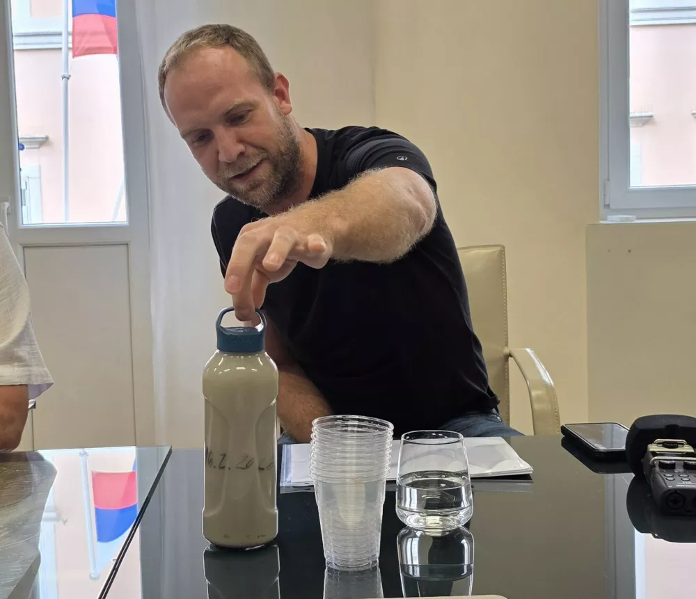 Miha Bertok iz Ribi&scaron;ke družine Koper, je pokazal motno vodo iz potoka v bližini gradbi&scaron;ča drugega tira. / Foto: Katja Gle&scaron;čič 