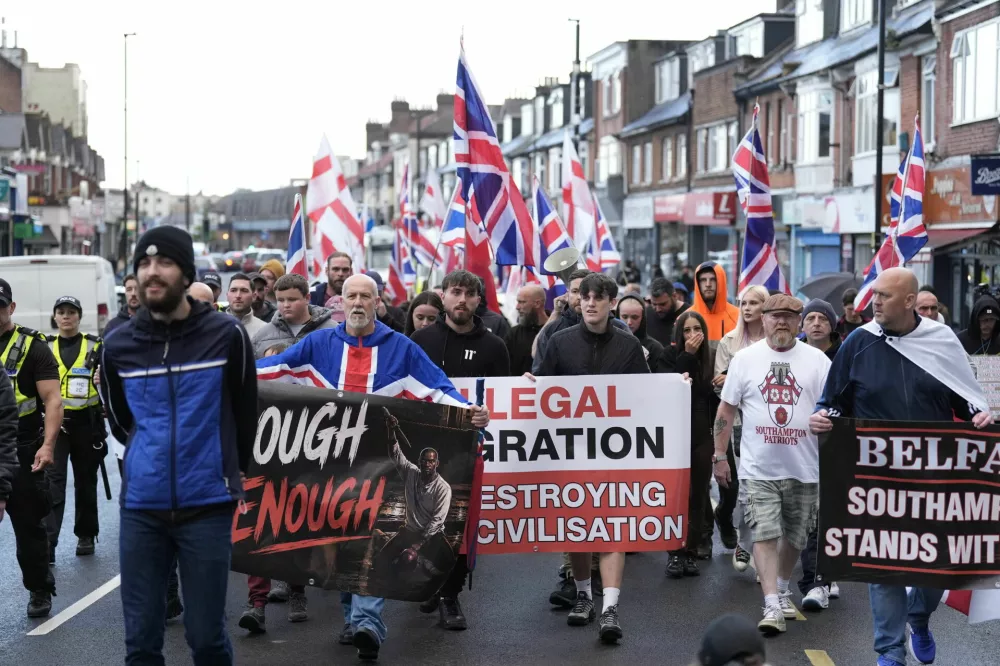 Demonstrators march along Portswood Road in Southampton, England, on Tuesday, June 9, 2026, during an Enough is Enough protest, after a man from Sudan was arrested over a knife attack in Belfast. (Andrew Matthews/PA via AP)