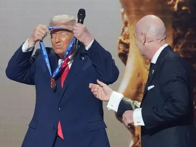 FILE - President Donald Trump puts on the inaugural FIFA Peace Prize presented to him by FIFA President Gianni Infantino during the 2026 FIFA World Cup draw at the Kennedy Center in Washington, Dec. 5, 2025. (AP Photo/Evan Vucci, File)