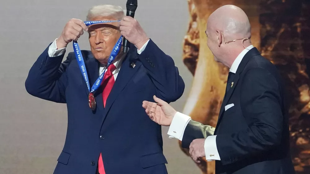 FILE - President Donald Trump puts on the inaugural FIFA Peace Prize presented to him by FIFA President Gianni Infantino during the 2026 FIFA World Cup draw at the Kennedy Center in Washington, Dec. 5, 2025. (AP Photo/Evan Vucci, File)