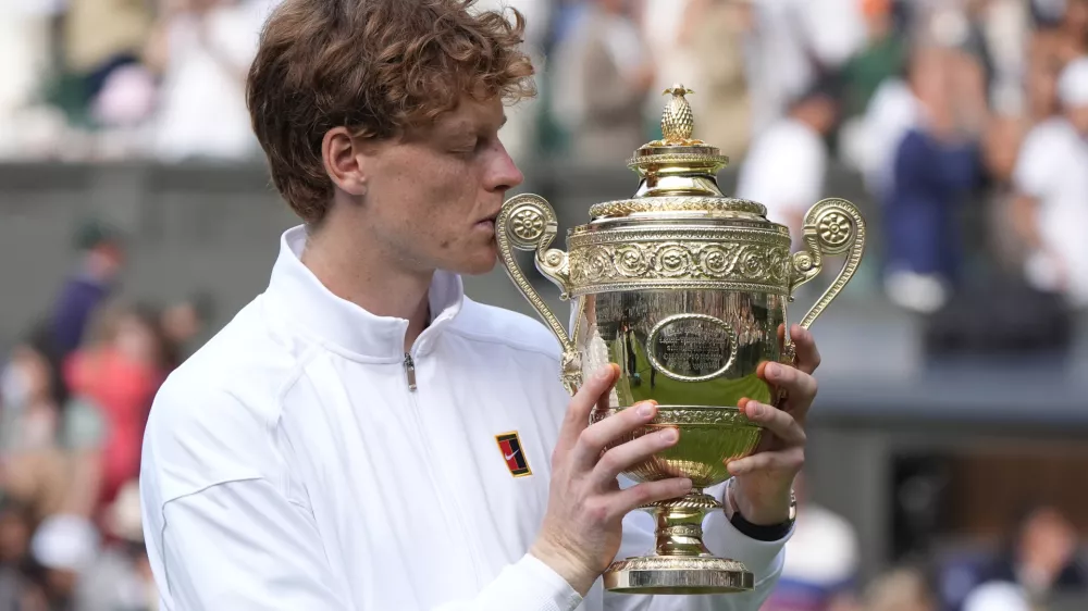 FILED - 13 July 2025, United Kingdom, London: Italian tennis player Jannik Sinner kisses the Gentlemen's Singles Trophy following his victory over Spain's Carlos Alcaraz in the Gentlemen's Singles Final on day fourteen of the 2025 Wimbledon Championships at the All England Lawn Tennis and Croquet Club. Photo: Andrew Matthews/PA Wire/dpa