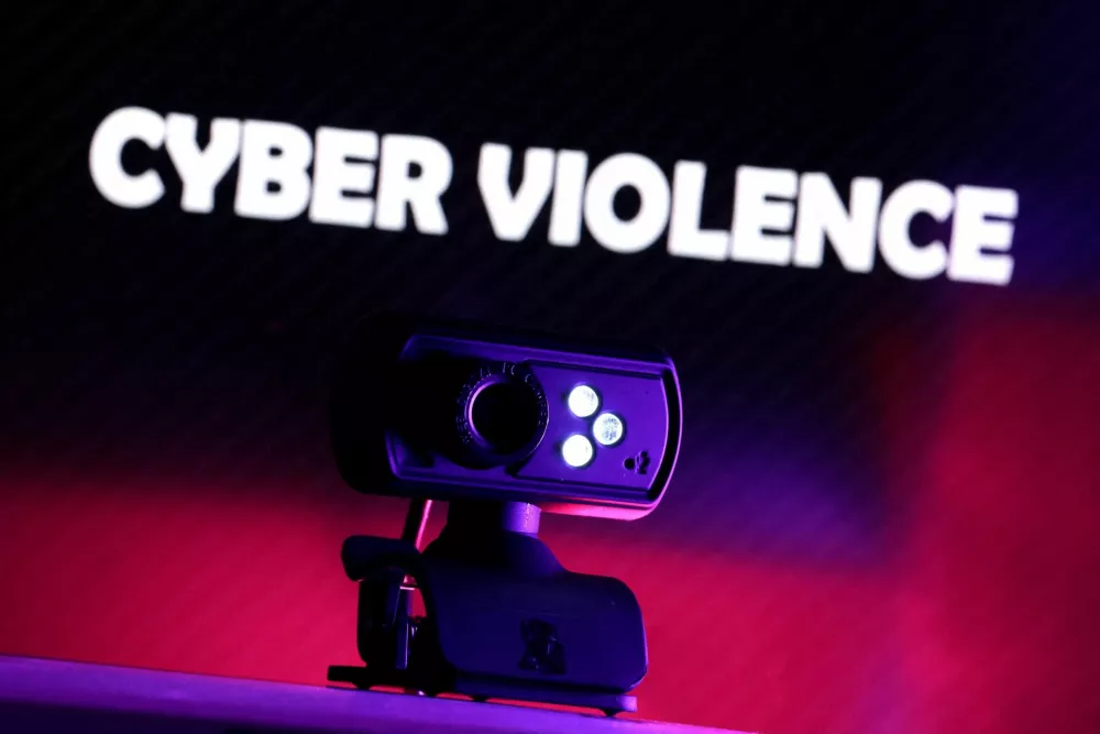 FILE PHOTO: A web camera is seen in front of the displayed words "Cyber violence" in this illustration taken October 21, 2025. REUTERS/Dado Ruvic/Illustration/File Photo