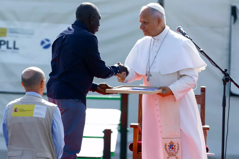 Pope Leo XIV receives a photo collage from Senegalese migrant Theodor Faye at the "Las Raices" migrant center in Tenerife, Canary Islands, Spain, June 12, 2026, where he is meeting migrants and humanitarian organizations, as part of a seven-day apostolic journey to Spain, with visits to Madrid, Barcelona and the Canary Islands. REUTERS/Borja Suarez