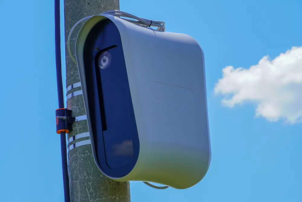 Closeup of a modern speed camera (traffic speed monitoring camera) against a clear blue sky