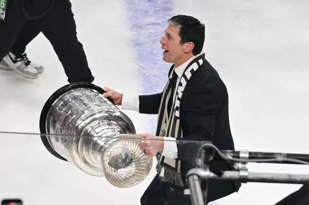 Carolina Hurricanes head coach Rod Brind'Amour, right, lifts the Stanley Cup after a win over the Vegas Golden Knights in Game 6 of the NHL hockey Stanley Cup Final series, Sunday, June 14, 2026, in Las Vegas. (AP Photo/Candice Ward)