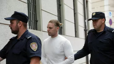 Robert DiCaprio aprila 2026 v spremstvu policistov. V malo manj glamurozni različici kot na objavah na spletnih družbenih omrežjih. 
