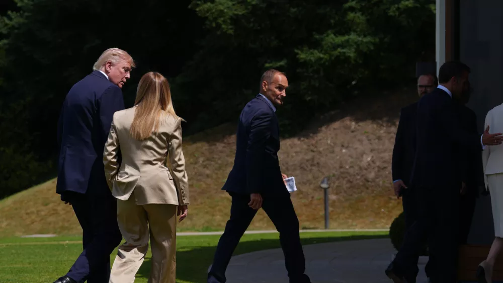 U.S. President Donald Trump, left, speaks with Italian Prime Minister Giorgia Meloni, second left, after a group photo of G7 leaders and invited nations during the G7 summit in Evian-les-Bains, France, Tuesday, June 16, 2026. (AP Photo/Thibault Camus)