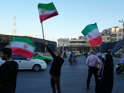 Demonstrators wave Iranian flags as they chant slogans against Iran and U.S. talks at the Islamic Revolution square in Tehran, Iran, Sunday, June 14, 2026. (AP Photo/Vahid Salemi)