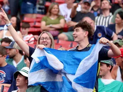 Fans of the Scotland men's soccer team sing and dance before a baseball game between the Boston Red Sox and the Texas Rangers, Sunday, June 14, 2026, in Boston. (AP Photo/Mark Stockwell)