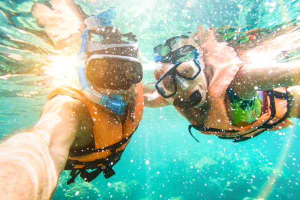 Senior happy couple taking selfie in tropical sea excursion with water camera - Boat trip snorkeling in exotic scenarios - Active retired elderly and fun concept on scuba diving - Warm vivid filter / Foto: Viewapart