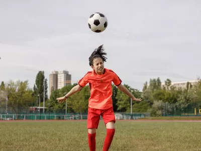 A girl soccer player heading the ball / Foto: Istock