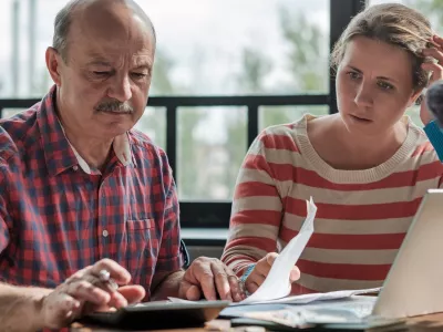 Spanish man counting money with his daughter sitting in the living room. Helping children while retired. / Foto: Koldunov Getty Images