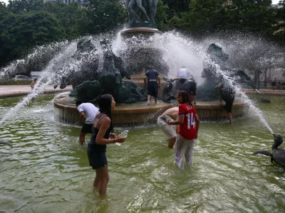 Young people cool off in the Fontaine de l'Observatoire fountain as temperatures rise in Paris and a heatwave hits a large part of France, June 18, 2026. REUTERS/Abdul Saboor