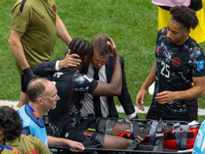 Canada head coach Jesse Marsch embraces Ismael Kone (8) as he is stretchered off the field after an injury during the World Cup Group B soccer match between Canada and Qatar in Vancouver, British Columbia, Thursday, June 18, 2026. (Timothy Matwey/The Canadian Press via AP)