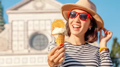 Young happy asian tourist woman eating ice-cream in front of the Croce basilica church in Florence