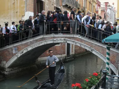 VENICE, ITALY - MAY 18, 2012: Tourists in the crowded the bridge in Venice.