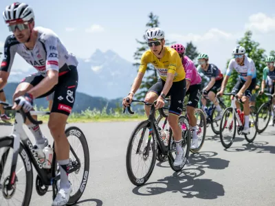 Tadej Pogacar, center, from Slovenia of UAE Team Emirates-XRG competes during the fifth and final stage, a 151 km race with start and finish in Villars-sur-Ollon, Switzerland, at the 89th Tour de Suisse UCI World Tour cycling race, on Sunday, June 21, 2026. (Gian Ehrenzeller/Keystone via AP)